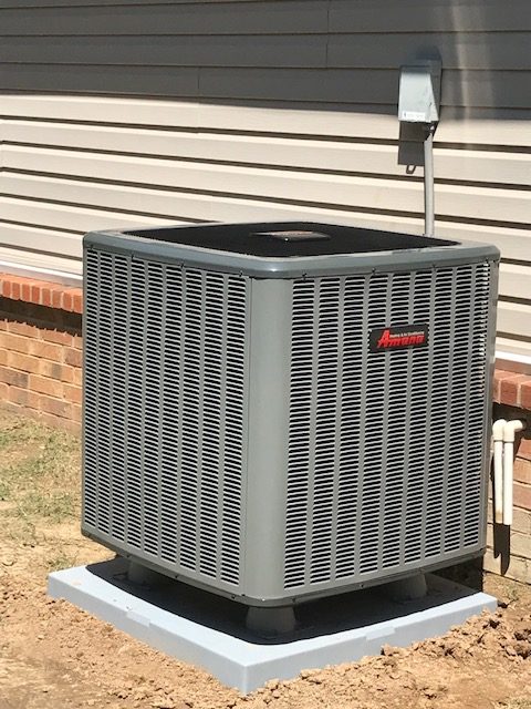 A central air conditioner compressor installed outside a home.
