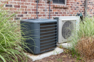 air conditioner compressor unit next to a mini-split unit outside a brick home